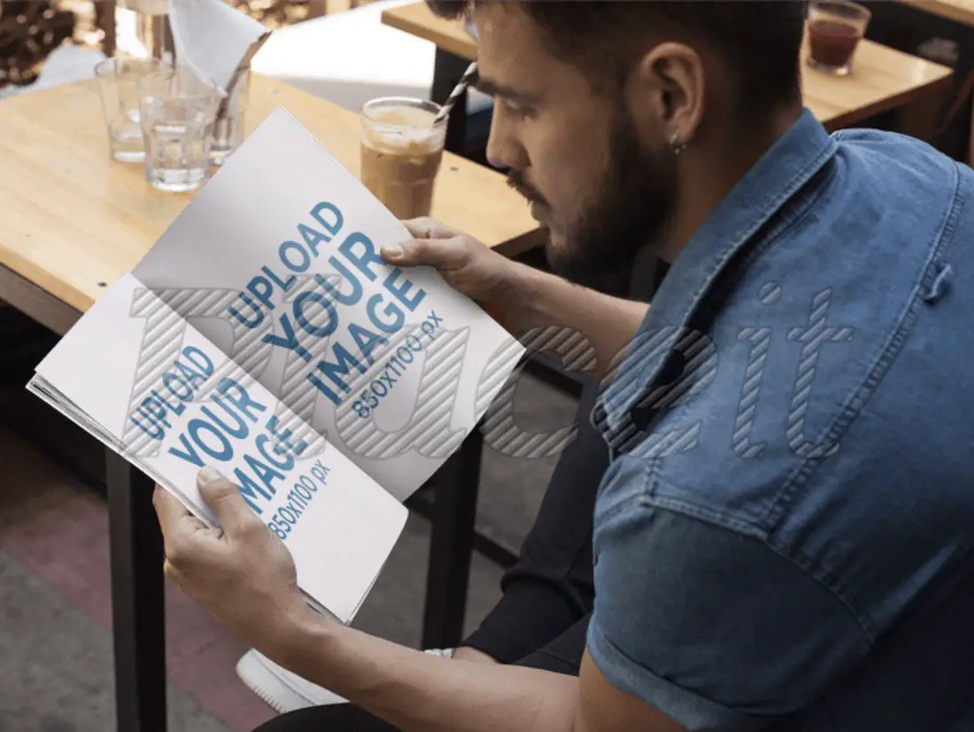 jeune homme à la barbe lisant une maquette de magazine